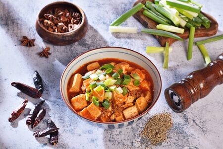 A bowl of rice with mapo doufu on a tableの写真素材