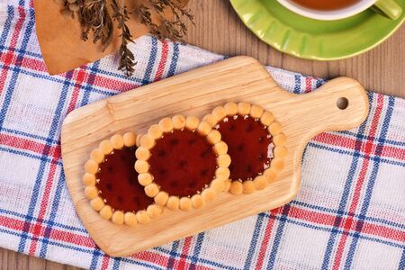 Raspberry jam tarts on wooden boardの写真素材