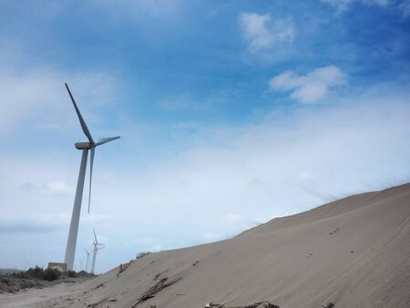 Beautiful dune and windmill in the beach dunes hill at Guanyin, Taiwanの写真素材