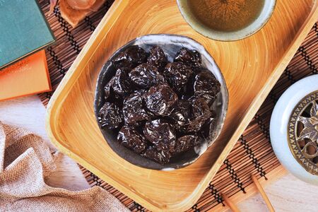 Dried black dates on black plate
