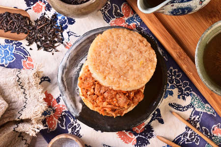Rice burger with kimchi pork on a black plateの写真素材