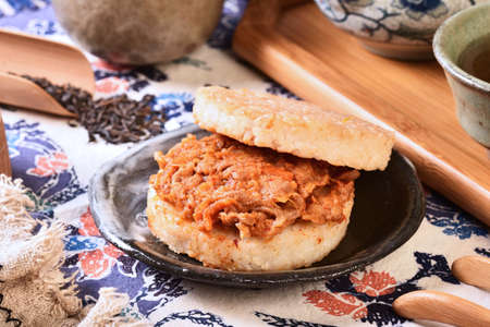 Rice burger with kimchi pork on a black plateの写真素材