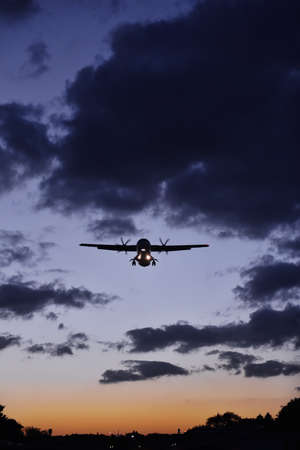 A plane landing at sunset