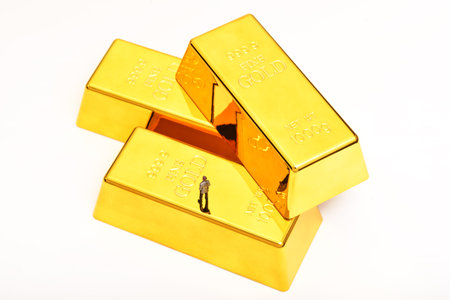 Miniature people figure businessman stand on pile of gold bar.の写真素材