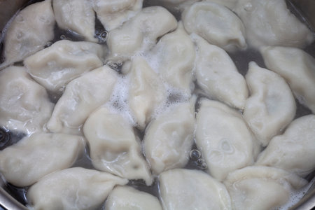 Meat dumplings are boiled in a pot of boiling waterの写真素材