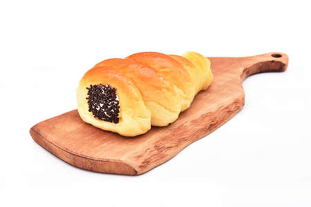 Cream cornet roll bread with raw chocolate on wooden tray