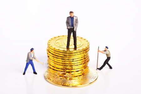 Miniature people businessman standing on golden coins, business, and financial concept.