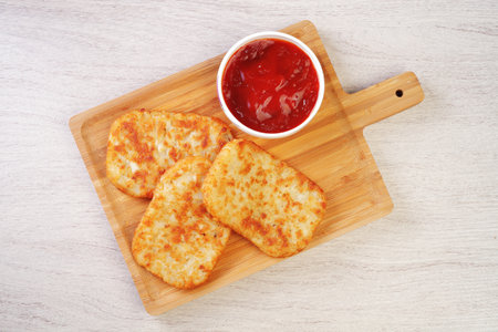 Hash browns on wooden cutting boardの写真素材