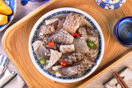 Cold fish skin in sauce in a bowl on a wooden tableの写真素材