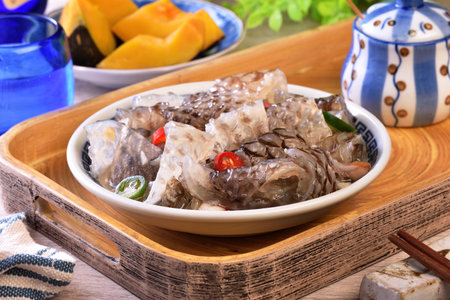 Cold fish skin in sauce in a bowl on a wooden tableの写真素材