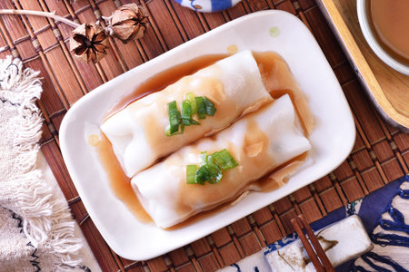 Steamed rice rolls with fresh prawn filling served in a dish on wooden tableの写真素材