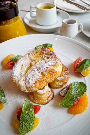 French toast with apricot jam and mint on a white plateの写真素材