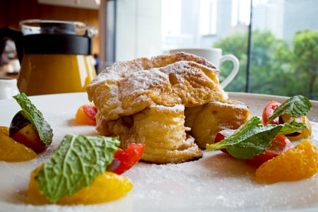 French toast with orange and mint on a white plate in a cafeの写真素材