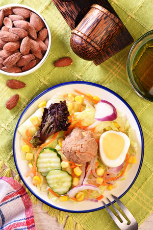 Tuna salad with corn, lettuce, red onions, boiled egg, radish, cucumber and canned tuna.の写真素材