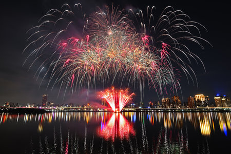 Colorful fireworks of various colors over night sky with reflection in water