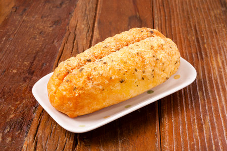 Garlic butter cheese bread on a white plate on a wooden background.