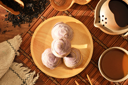 Taro cake on wooden plate and tea setの写真素材