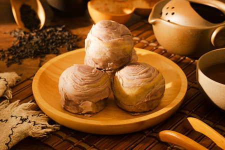 Taro cake on wooden plate and tea setの写真素材