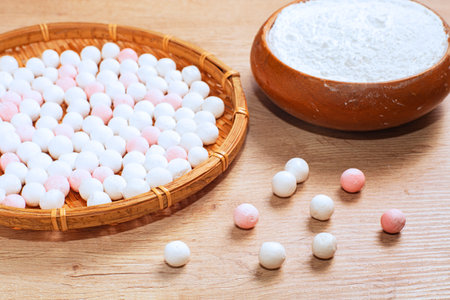 Close up of white and pink rice balls in bamboo basket on wooden backgroundの写真素材