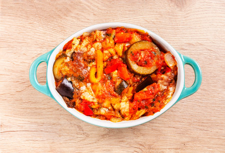 Provence roasted vegetables, baked vegetables in a baking dish on a wooden tableの写真素材
