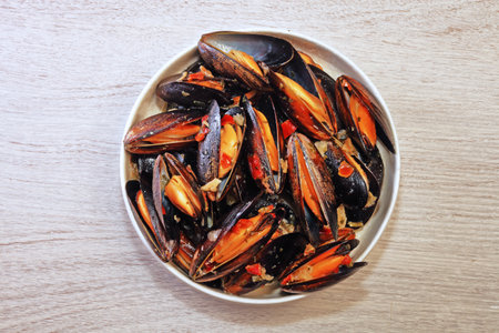 Mussels in garlic cream sauce on wooden tableの写真素材