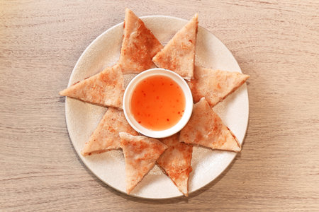 Fried moon shape shrimp cake with sauce on wooden table