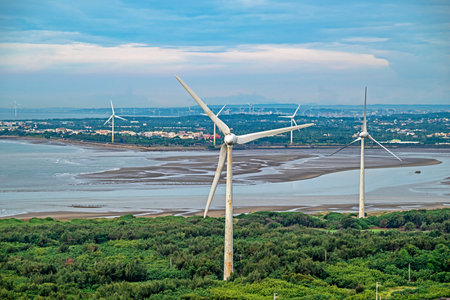 Tall white wind turbines stand near the coast and in the town.