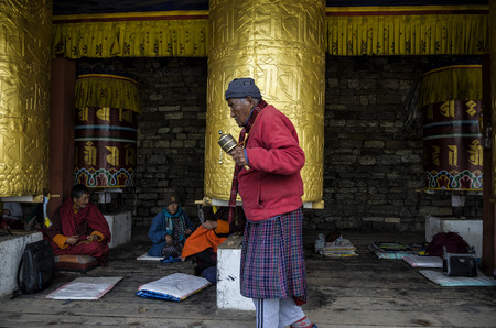 Unidentified pilgrimage near spinning Big Tibetan Buddhist prayer wheel at the National Memorial Chorten located in Thimphu, Bhutan.のeditorial素材