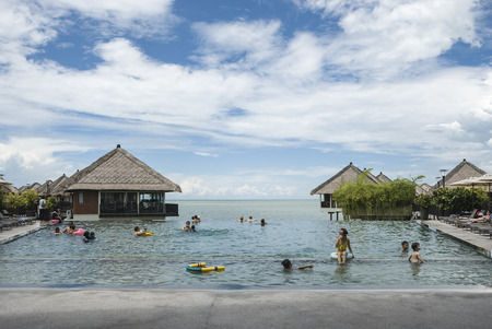 Sepang, Malaysia - People cooling off and relaxing at swimming pool during seasonal summer holiday - relaxing infinity swimming pool lifestyle conceptのeditorial素材
