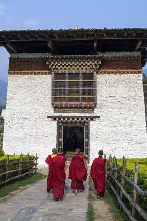 Unidentified biddhist monks with traditional robes are entering the Punakha Dzong or Pungthang Dewachen Phodrang monastery, Punakha, Bhutan.のeditorial素材