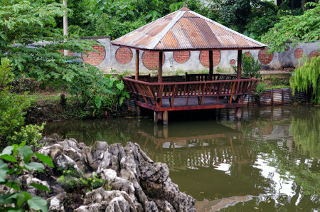Old hut beside the pond - Small wooden hut on the shore of a pond.の写真素材