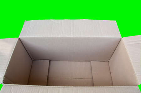 An open square cardboard box on a green background.の写真素材