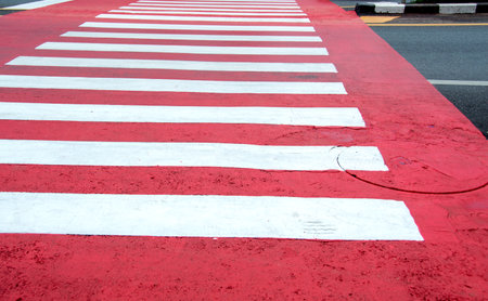 Red and white zebra crossing on city streets during daytime