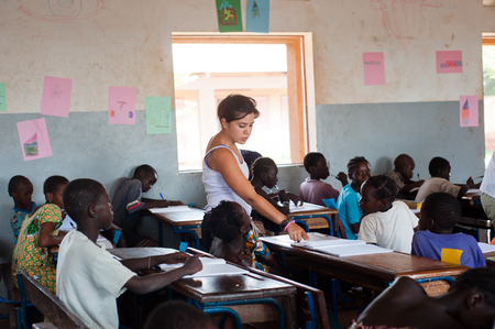 Mali, Africa - Circa August 2009 - White woman teaching to black children in a typical classroom near Bamakoのeditorial素材
