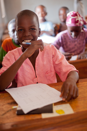 Mali, Africa - Circa August 2009 - Closeup portrait of a black african primary school male student relaxing during a break at the middle of morningのeditorial素材