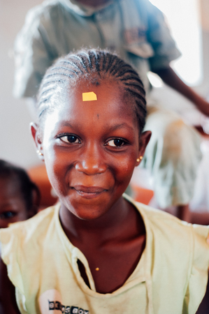 Mali, Africa - Circa August 2009 - Closeup portrait of a black african female primary school student relaxing during a break at the middle of morningのeditorial素材