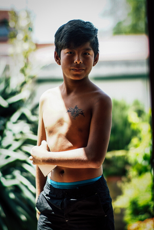 Latin boy portrait outdoor. Summer season. Dragon tattoo on his bodyの写真素材