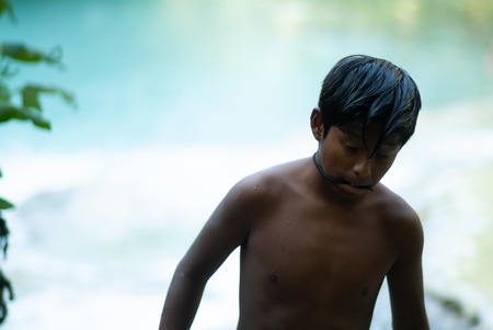 Latin boy having fun getting a bath in the middle of October on a turquoise water river. Global warming affects water temperature. SentierElsa, Colle Val dElsa. Tuscany Italy Europeの写真素材