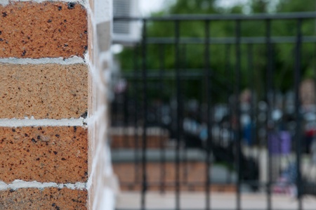 Brick wall closeup with blurred neighborhood background.の素材