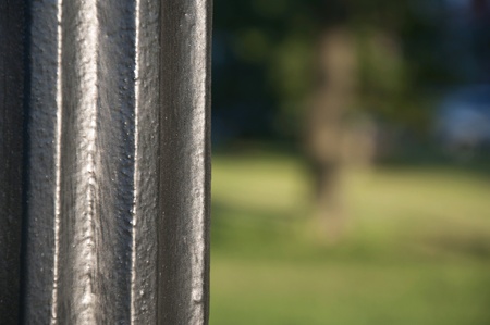Pole closeup with blurred view of the park.の素材