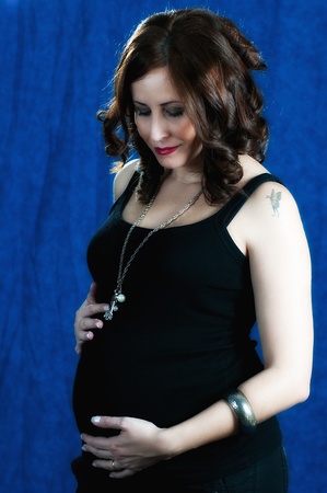 studio shot of a young brunette pregnant womanの写真素材
