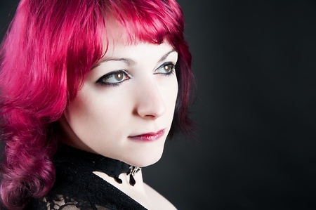 a young seductive redheaded girl on a black backgroundの写真素材