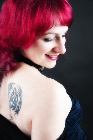 a young seductive redheaded girl on a black backgroundの写真素材