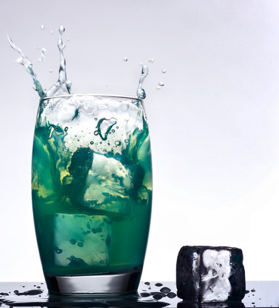 ice splash on a glass of fresh mint flavored drink  on a gradient の写真素材
