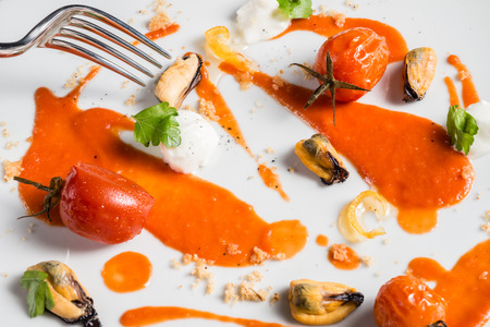 tomato, mozzarella cheese mussels and basil on a white dishの写真素材