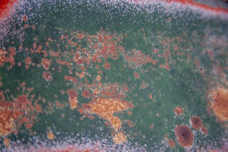Old metal sign weathered , showing multicolor patina patterns of orange, mauve, pink, green, rust,...