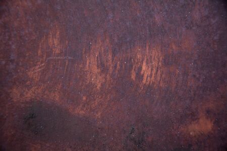 Old metal car door weathered, rusty and nearly paintless, showing multicolor patina patterns of...