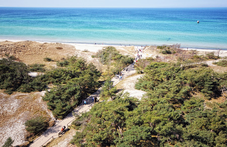Darsser Ort at Baltic sea beach on Darss peninsula (Mecklenburg-Vorpommern, Germany). Typical landscape with dunes and pine tree. People walking towards the beachの写真素材