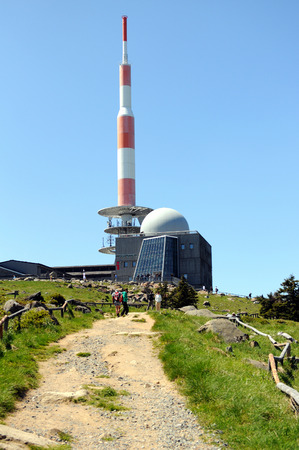 BROCKEN MOUNTAIN, SAXONY-ANHALT / GERMANY May 26 2012: People visiting Brocken Mountain National Park at resin (Germany). On the peak are the typical red white communication tower and a hotel. In background a group of hiking people walking around on peak.のeditorial素材
