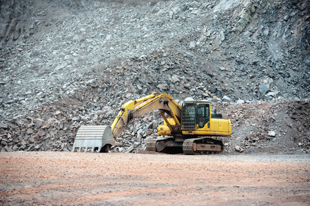 view in a quarry mine with excavator machine. porphyry rock.